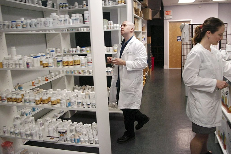 GLENSIDE, PA - SEPTEMBER 7: Pharmacist Howard Brooker(C) and his wife Pam Harvey (R) fill a prescription at Adams Discount Pharmacy September 7, 2006 in Glenside, Pennsylvania. Adams offers generic drugs for forty to seventy five percent cheaper than the brand name manufacturer's cost. They are able to charge low prices by not dealing with insurance companies. (Photo by William Thomas Cain/Getty Images)